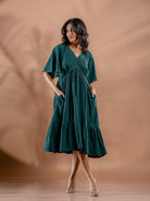 Front view of teal green summer cotton dress with relaxed fit and pocket details