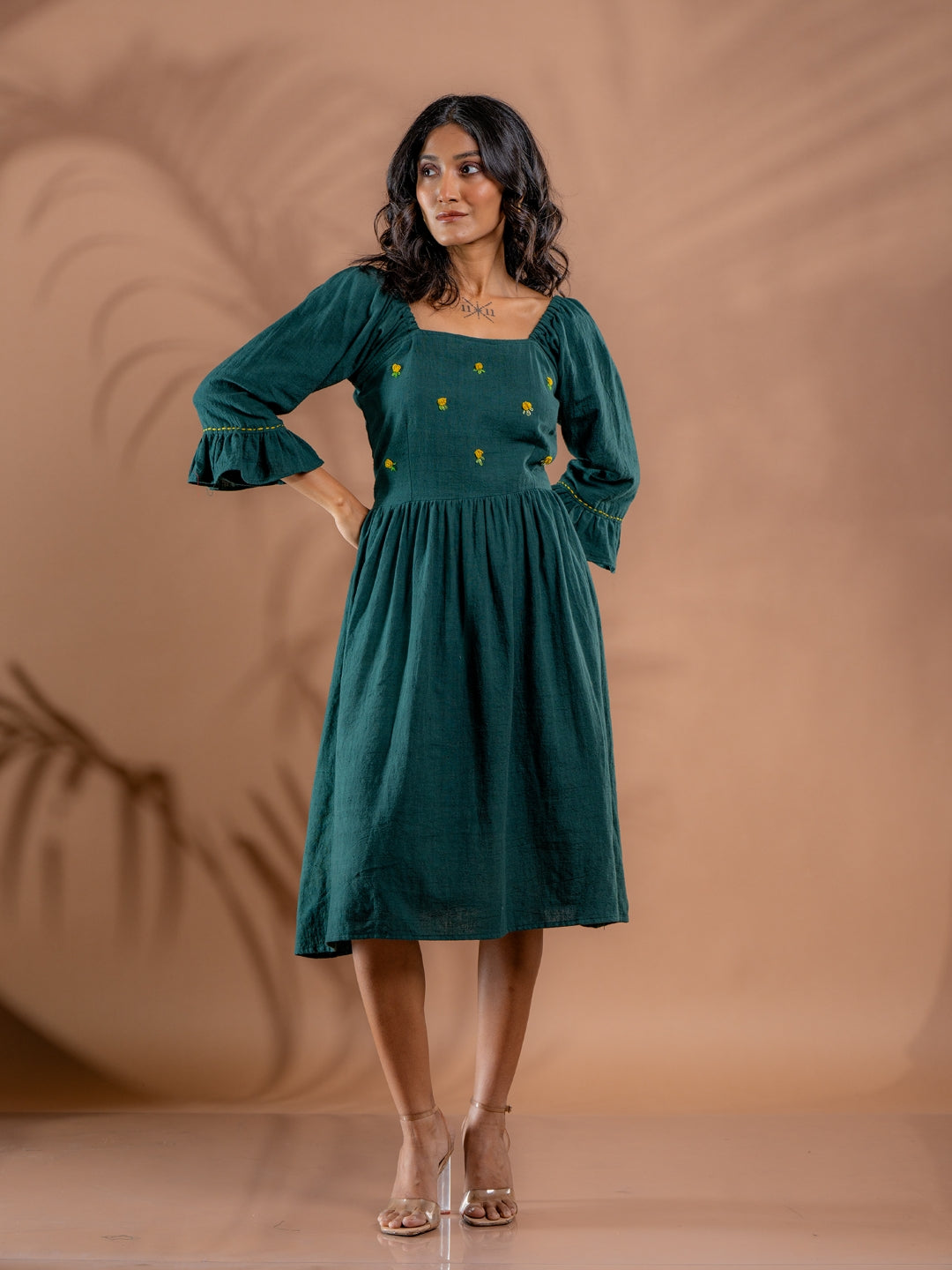 Front view of Teal green summer cotton dress, highlighting delicate hand embroidery details on bodice and sleeves. Sustainably made in India in handloom Kala cotton.
