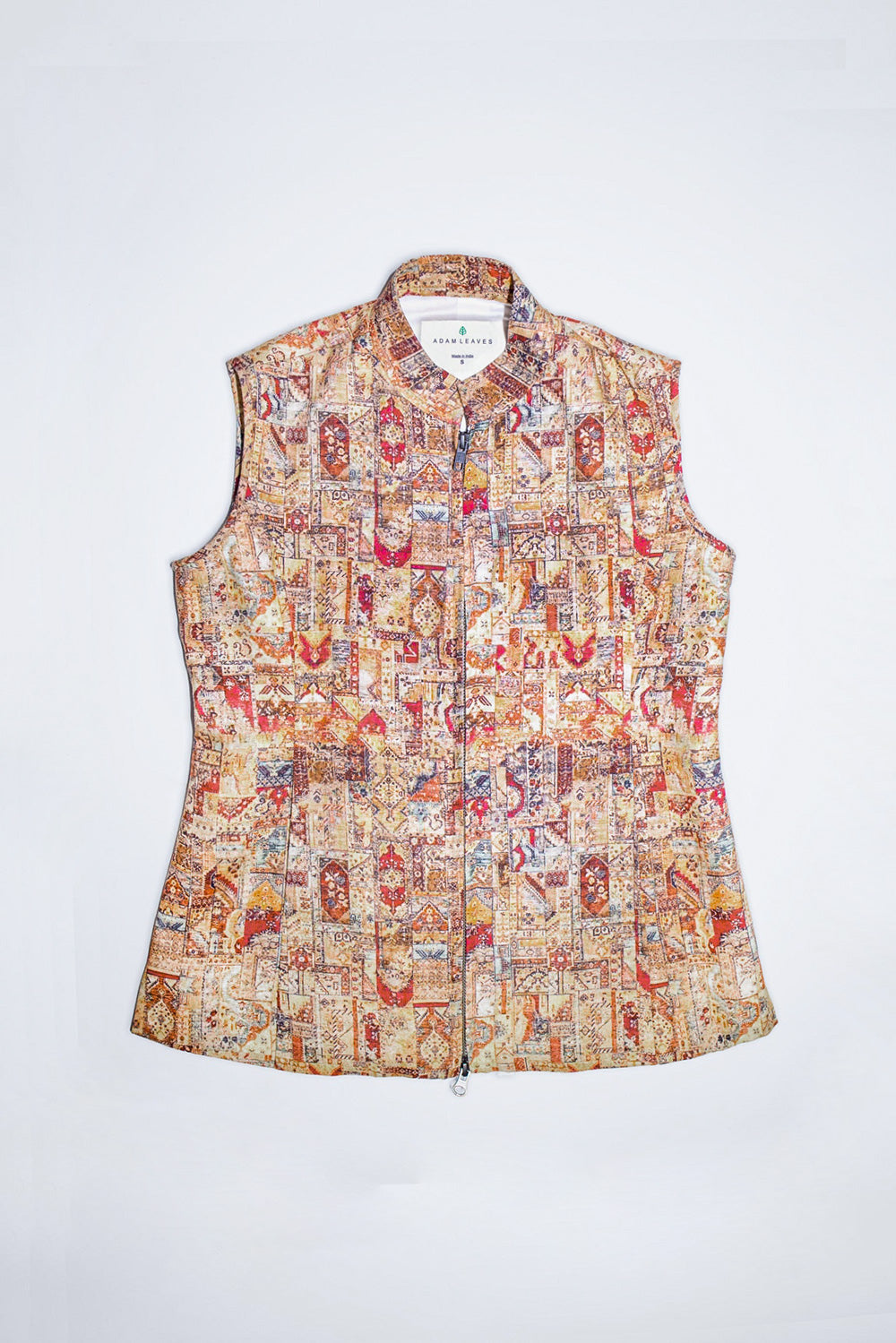 A sleeveless collared  linen vest with a front zipper, featuring an intricate multicolor patchwork print with red, blue, yellow, and brown motifs on a light beige background, shown flat against a white background.