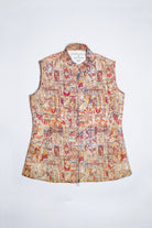 A sleeveless collared  linen vest with a front zipper, featuring an intricate multicolor patchwork print with red, blue, yellow, and brown motifs on a light beige background, shown flat against a white background.