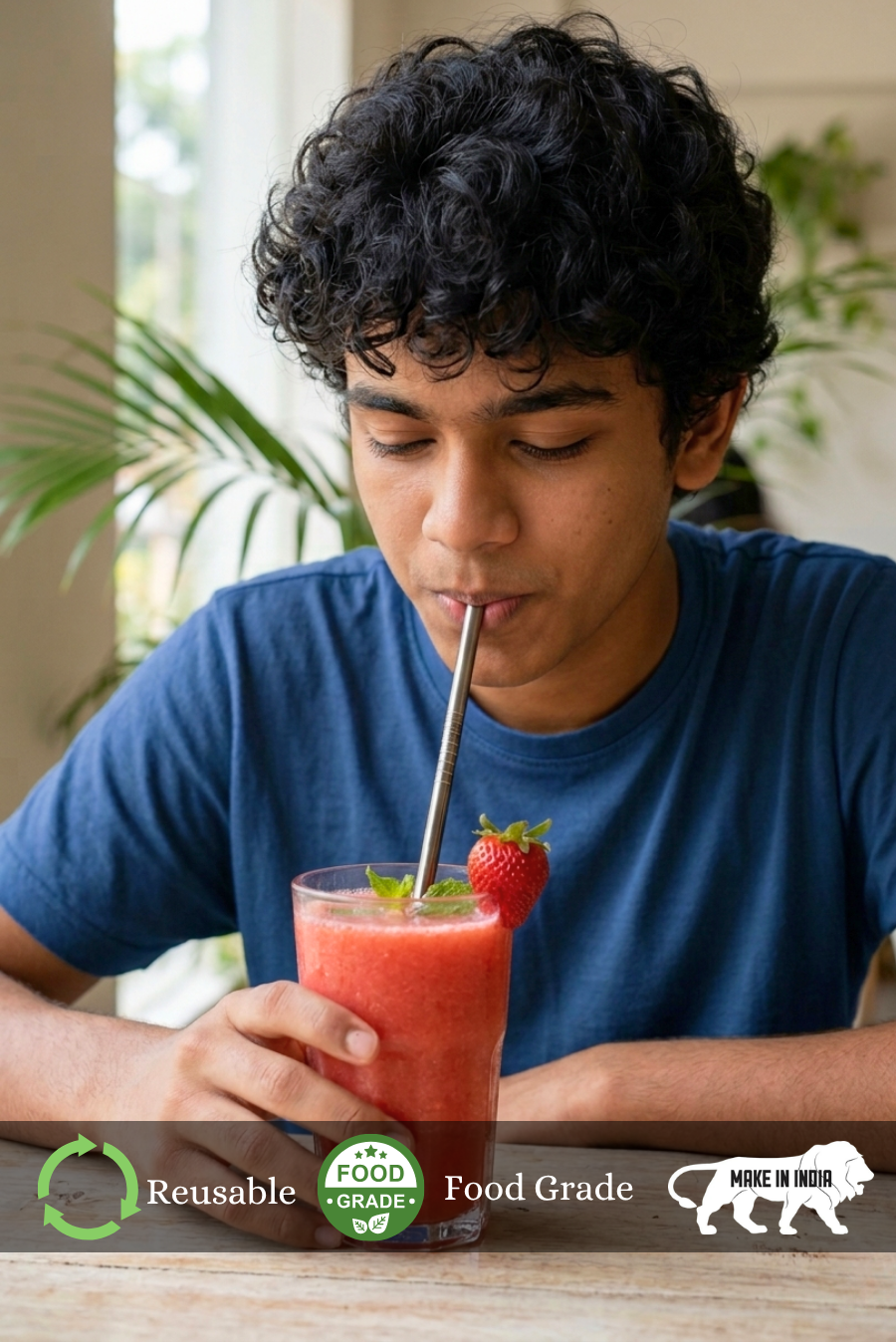 A boy drinking a strawberry smoothie with a Reusable Stainless Steel Straw  straw, surrounded by greenery