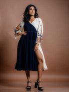 Model styling shot of Selene kala cotton  midi dress featuring faltering silhouette and front slit 