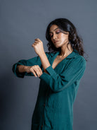 Close-up of handwoven teal green kala cotton fabric and lapel collar and sleeve detail  on women's shirt dress