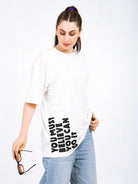 Woman modeling a white oversized bamboo T-shirt with motivational text and casual jeans.