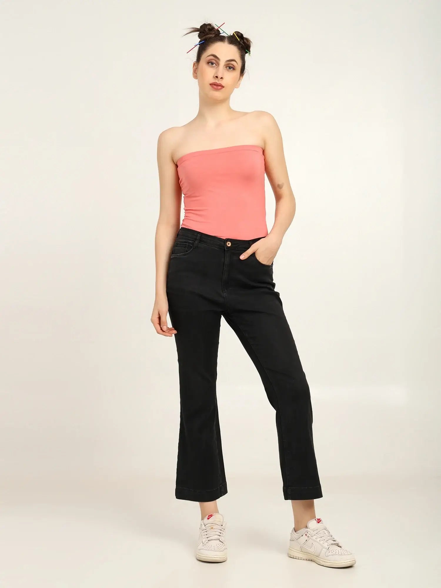 Gen Z women in a soft pink bamboo tube top styled with black cropped jeans for a trendy look.