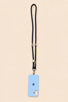 A light blue phone case with a black lanyard strap and gold-tone hardware, shown flat against a solid pale beige background.